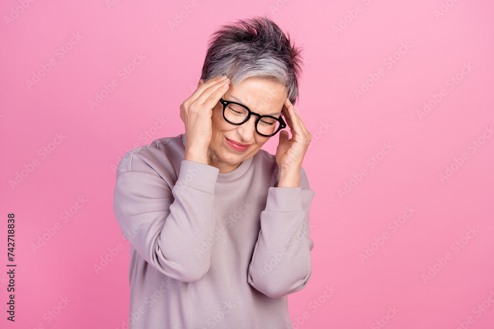 Photo of sad exhausted tired woman hand touch temples suffering migraine symptom syndrome feel unwell isolated on pink color background Photo of sad exhausted tired woman hand touch temples suffering migraine symptom syndrome feel unwell isolated on pink color background