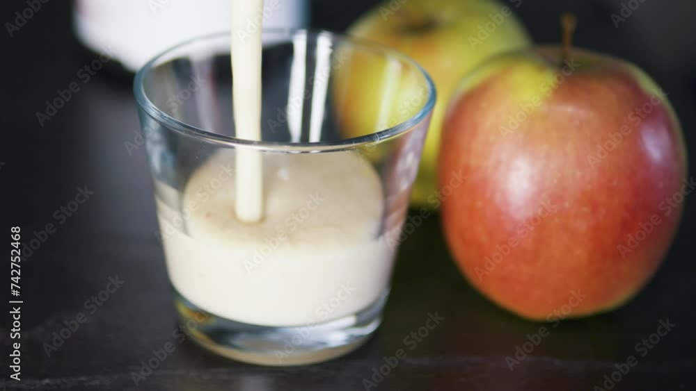 Pouring thick greek yoghurt oatmeal and apple smoothie into glass. Close up. Pouring thick greek yoghurt oatmeal and apple smoothie into glass. Close up.