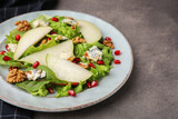 Delicious pear salad on dark textured table, closeup