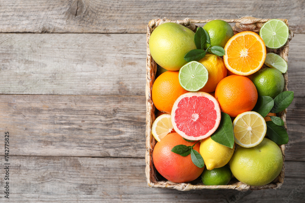 Different cut and whole citrus fruits on wooden table, top view. Space for text Different cut and whole citrus fruits on wooden table, top view. Space for text