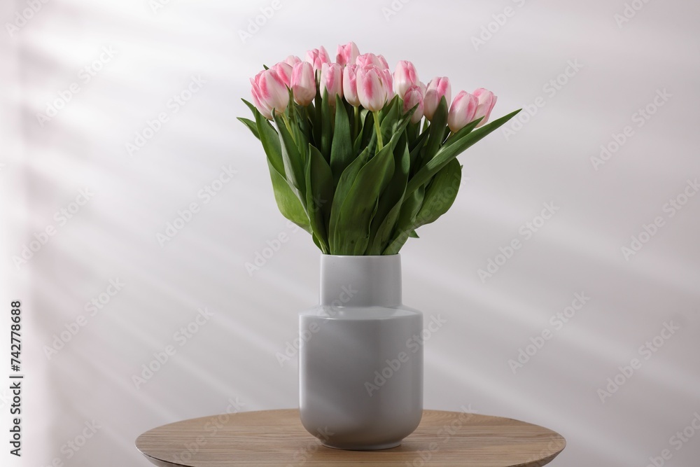 Beautiful bouquet of fresh pink tulips on table against light background Beautiful bouquet of fresh pink tulips on table against light background