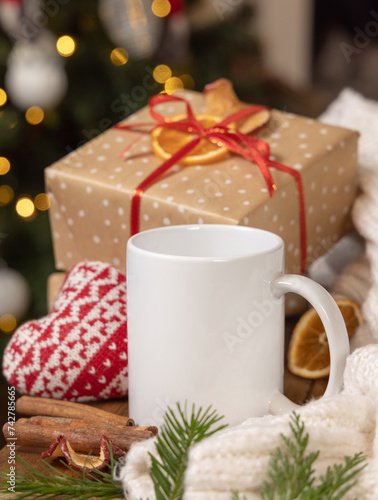 White coffee mug near Christmas present, cosy heart and sweater, winter atmospheric mockup