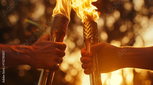 A close-up of the Olympic torch being passed between two runners, capturing the flame's glow and the symbolic gesture of unity and peace.  © Muhammad