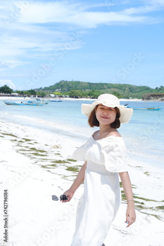 an Asian girl is enjoying a holiday on the beautiful Lombok beach with a tropical climate