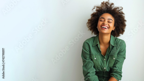 Afro woman wearing green shirt smiling laugh out loud isolated on grey