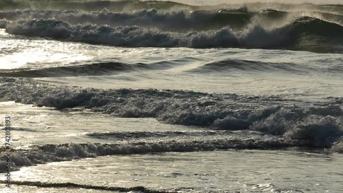 朝日を受け　次々に海岸に押し寄せる波　（スローモーション）