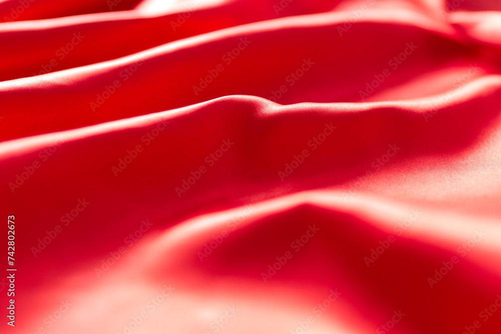The bright red silk satin surface is beautiful and luxurious, wavy. For background and graphic work Blurry or blurry The bright red silk satin surface is beautiful and luxurious, wavy. For background and graphic work Blurry or blurry