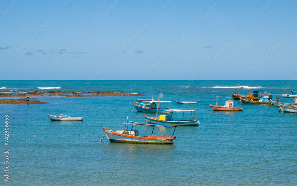 beach with boats in the sea with cloudless blue sky and space for text
