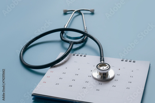 Stethoscope on calendar with soft focus and northern lights, annual checkup concept in the background. 