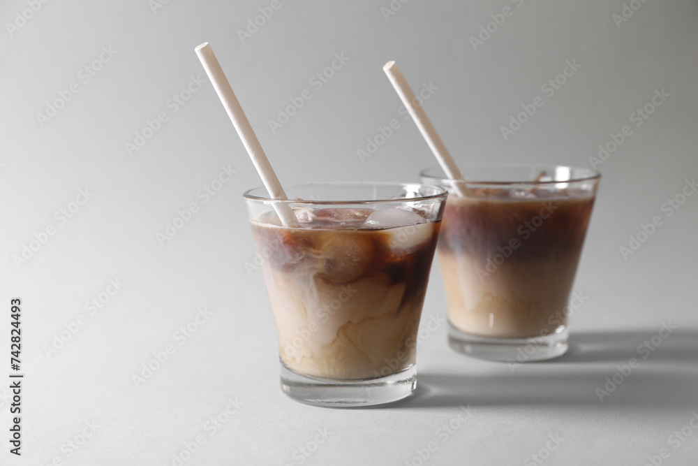 Refreshing iced coffee with milk in glasses on grey background. Space for text Refreshing iced coffee with milk in glasses on grey background. Space for text