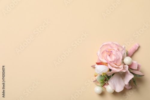 Stylish pink boutonniere on beige background, top view. Space for text