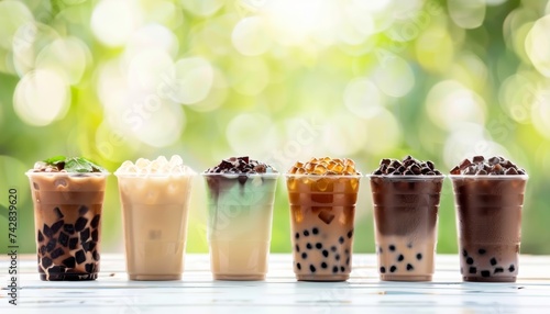 Assorted tapioca bubble teas on blurred coffee shop backdrop, with ample space for text placement. photo