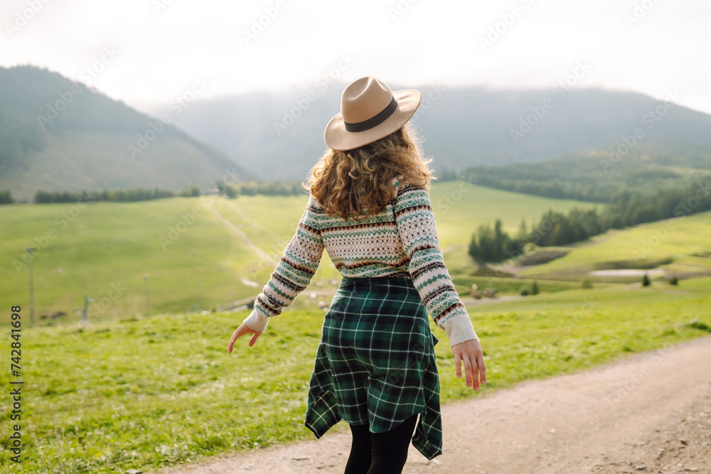 Beautiful woman walking in the field at sunny summer day. Nature, vacation, relax and lifestyle. Summer landscape.