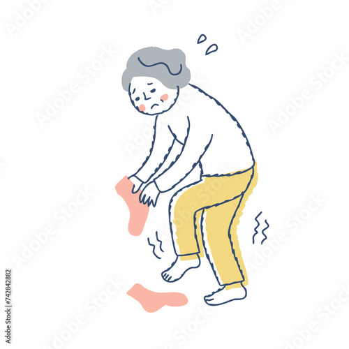 片脚立ちで靴下がはけないシニア女性