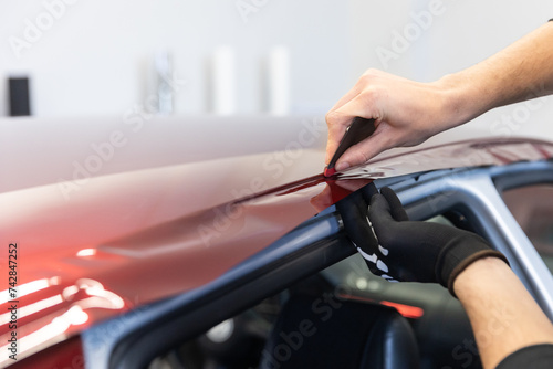 Process of gluing or wrapping a new foil wrap to a car, car detailing concept © Khaligo
