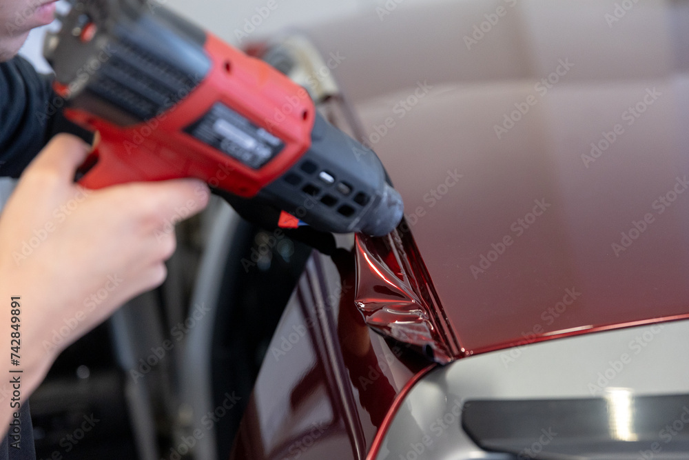 Wrapping a new foil to a car by heat gun, gluing a new foil, detailing concept Wrapping a new foil to a car by heat gun, gluing a new foil, detailing concept