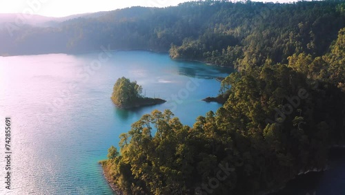Aerial shot of deep blue lake with small island and green forest in Chiapas photo