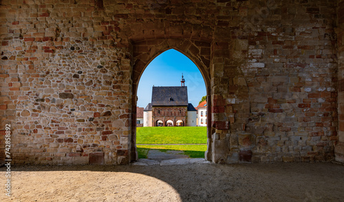 Fototapeta Naklejka Na Ścianę i Meble -  Lorsch Abbey with King’s Hall and Monastery Mound near Worms in Hessen Germany is public historical monument from the Carolingian Empire with park on a sunny summer day, frog perspective wide angle