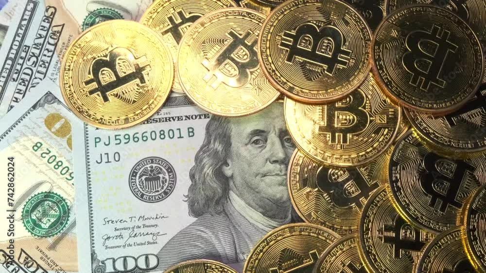 Golden physical Bitcoin coins on US dollars close up, rotating money background. Electronic crypto currency. Savings and investments concept.