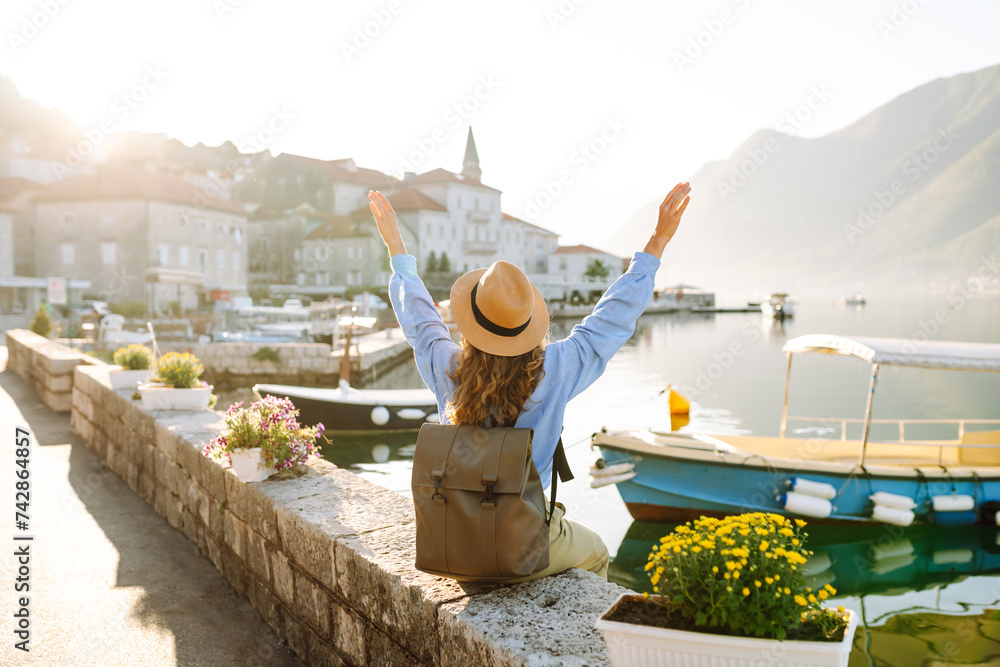 Young female tourist enjoys the view of the city. Europe travel. Lifestyle, vacation, tourism, nature, active life. - obrazy, fototapety, plakaty 