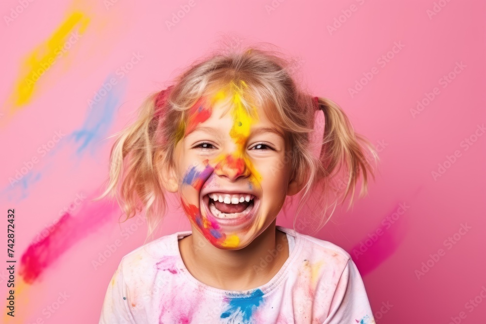 A cheerful young girl shows her hands covered with multicolored paint, her joy unmistakable against a pink background. A cheerful young girl shows her hands covered with multicolored paint, her joy unmistakable against a pink background.