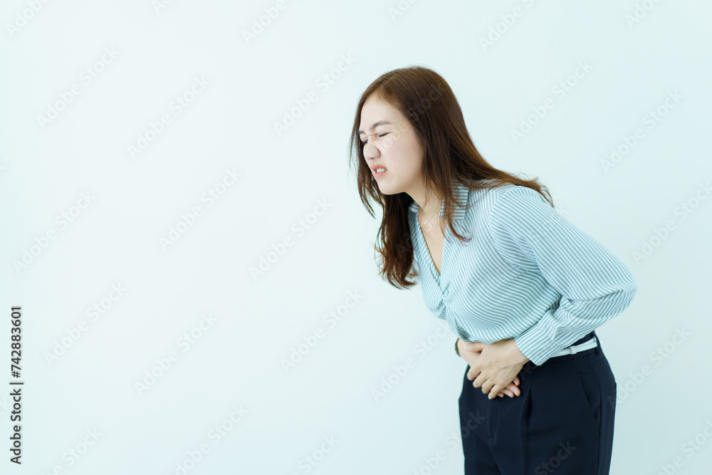 Asian woman in business casual wardrobe touching on her belly or stomach painfully. Asian woman in business casual wardrobe touching on her belly or stomach painfully.