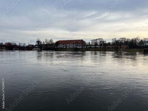 Poland, Gorzow Wielkopolski, 18 February 2024: View of the Warta River, bridge White Barn - a monument of the 18th century, now a branch of the Lubusz Museum. Warta River flood. Flooded shores. 