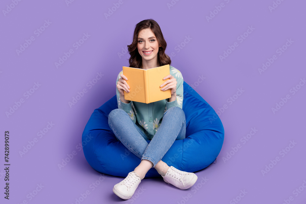 Full length photo of positive good mood woman wear flower print cardigan reading interesting book isolated purple color background Full length photo of positive good mood woman wear flower print cardigan reading interesting book isolated purple color background