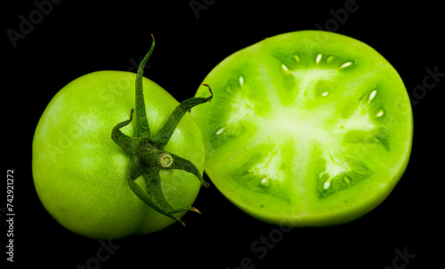 Green tomatoes isolated on black background.