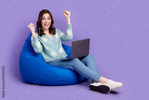 Full length photo of cute lucky woman wear flower print cardigan winning game modern device empty space isolated purple color background