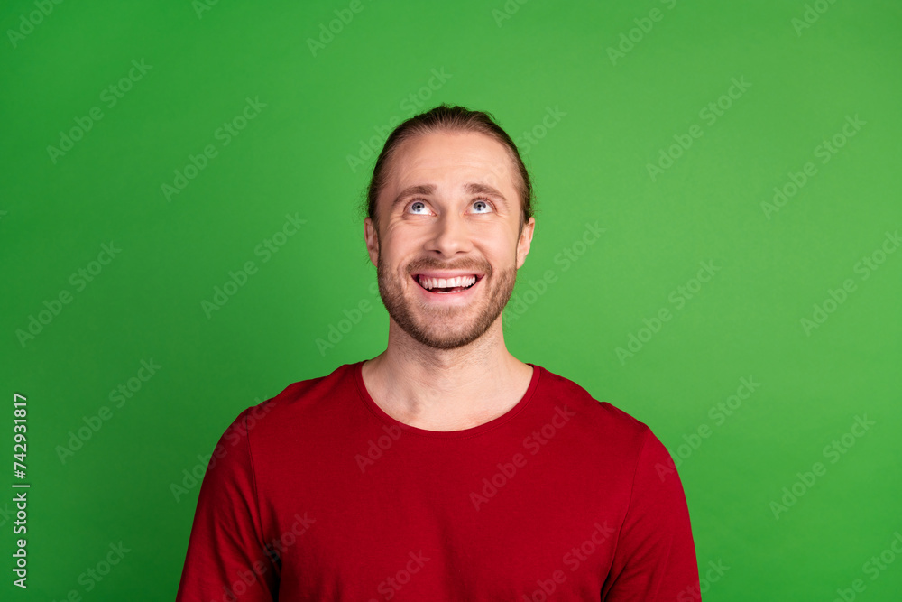 Photo of cheerful optimistic man with stubble dressed red pullover look at discount empty space isolated on green color background Photo of cheerful optimistic man with stubble dressed red pullover look at discount empty space isolated on green color background