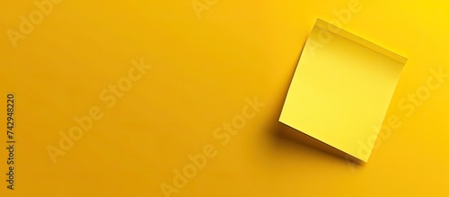 A yellow wall with a white square object mounted on it, possibly a frame or decorative element. The stark contrast between the colors creates a visually striking composition.