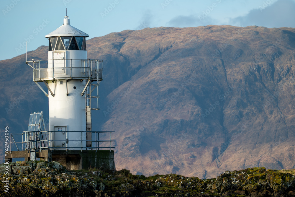 Sentinel of the Sea: Port Appin Coastal Lighthouse Against Mountain Backdrop