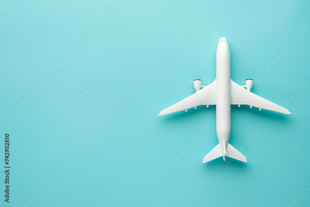 An air plane on blue background. Top view, white toy plane with copy space, minimal style. airliner, airplane, twin-engine jet aircraft. Travel and vacation concept An air plane on blue background. Top view, white toy plane with copy space, minimal style. airliner, airplane, twin-engine jet aircraft. Travel and vacation concept