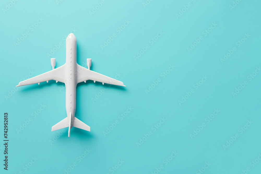 An air plane on blue background. Top view, white toy plane with copy space, minimal style. airliner, airplane, twin-engine jet aircraft. Travel and vacation concept An air plane on blue background. Top view, white toy plane with copy space, minimal style. airliner, airplane, twin-engine jet aircraft. Travel and vacation concept