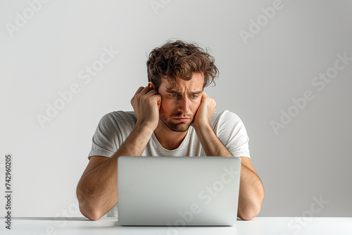 Man in frustration or procrastination and apathy at laptop computer. ADHD and depression, man absent-minded or frustrated with head in hands looking at laptop in procrastination and fatigue apathy photo