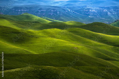 View of a green valley with hills along the Mount Elbrus, Karachay-Cherkess, The Caucasus, Russia. photo