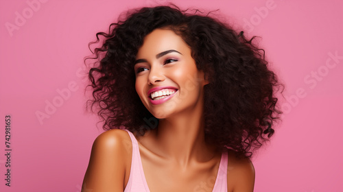 Curly girl with dark hair and perfect skin smiles and shows her white teeth on pink background, banner with space for your text