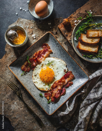Perfekt gebratenes Spiegelei mit knusprigem Bacon Ein herzhaftes Frühstück auf rustikalem Teller