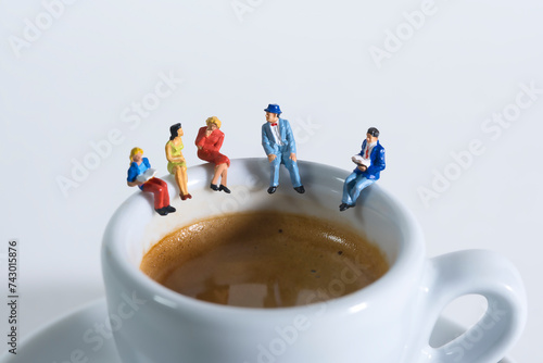 Photography of miniature people and toy figures, a group of people sits on a coffee cup for a break, close up
​