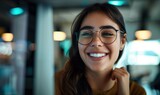 Beautiful young smiling female office worker with toothy smile wearing glassess working in the office smiling at camera with perfect teeth