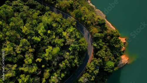 Cinematic shot of flying over the lake and road coast in Thailand national park with picturesque environment