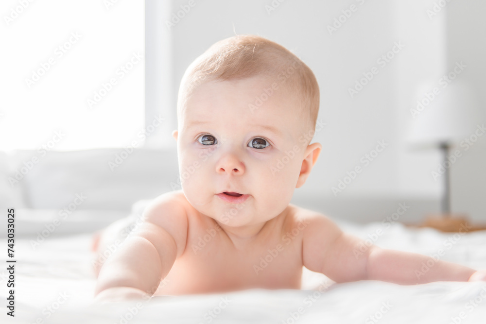 Adorable baby boy in white sunny bedroom. Adorable baby boy in white sunny bedroom.
