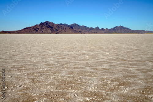 Unique hexagon salty pattern in the foreground and mountain silhouette at Bonneville Salt Flat near Wendover Utah United States