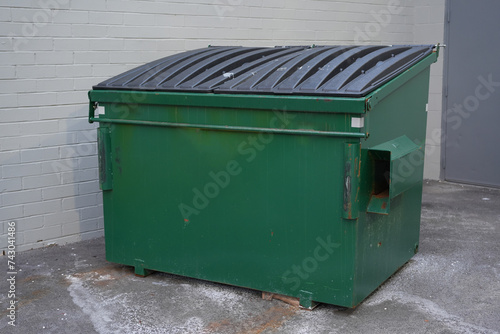 large green commercial dumpster for trash and recycling
