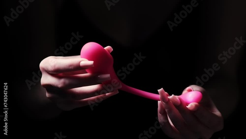 Pink vaginal vibrator for the G-spot in the hands of a girl on a black background. Sex Shop Products, Adult Gifts for Couples, Adult Store
