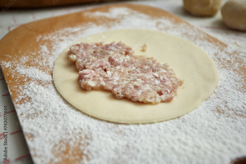 A piece of dough with minced meat for cheburek