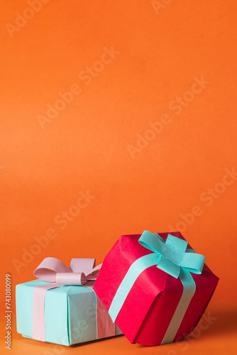 Colorful gift boxes on orange background with copy space.