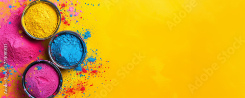 Holi background. Bowls of colorful gulal powder on yellow table flat lay with copy space. Festive Indian happy holidays greeting card, invitation or banner. Hindu festival of colours 8k backdrop.