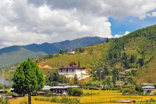 A panoramic view of the airport and the Paro Valley, Bhutan. Landscape with Mountain, river, green meadows and agricultural land, blue sky with white clouds. photo